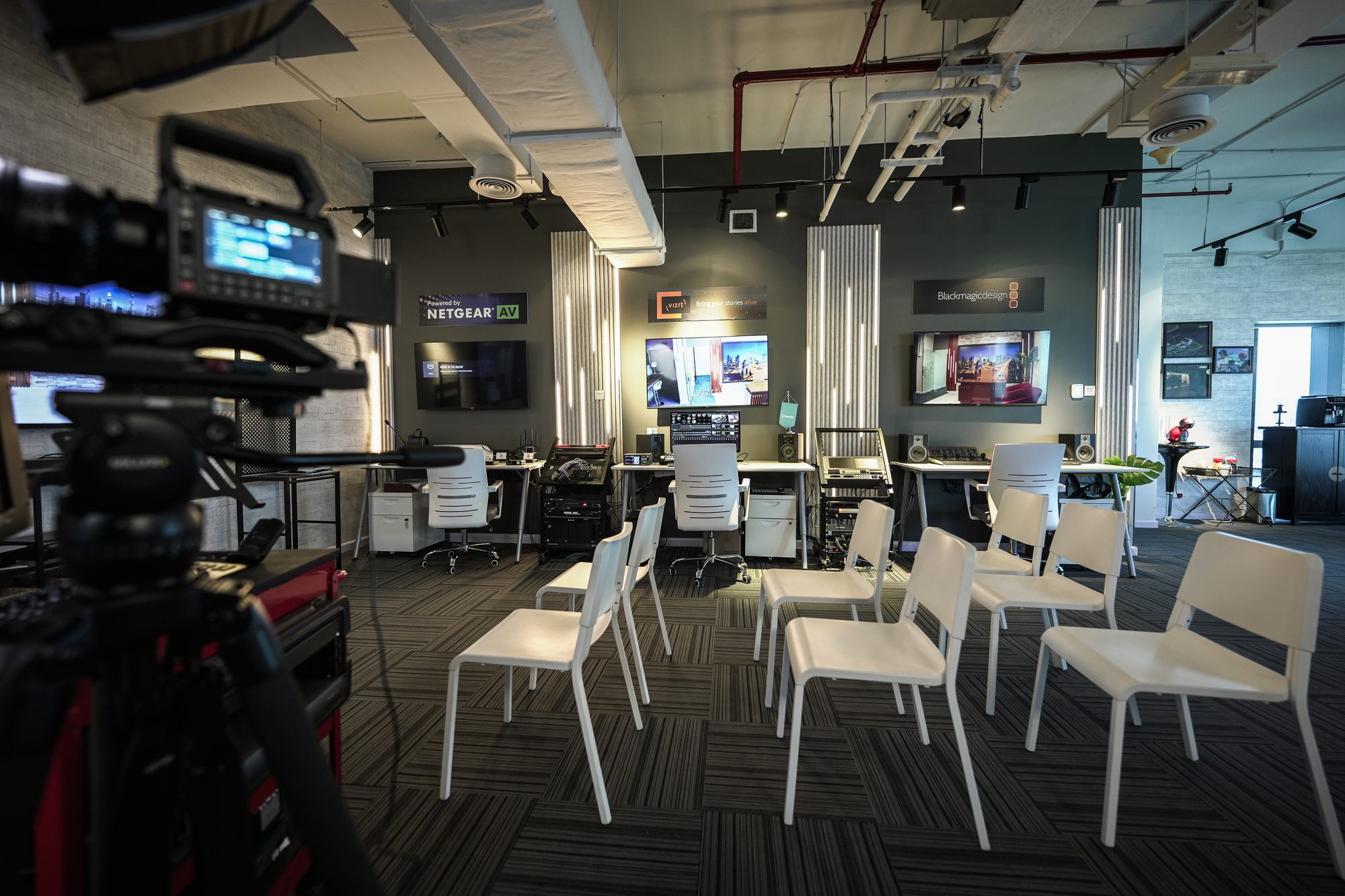 Rows of seating set out on the MCX floor, a camera at the back of the room