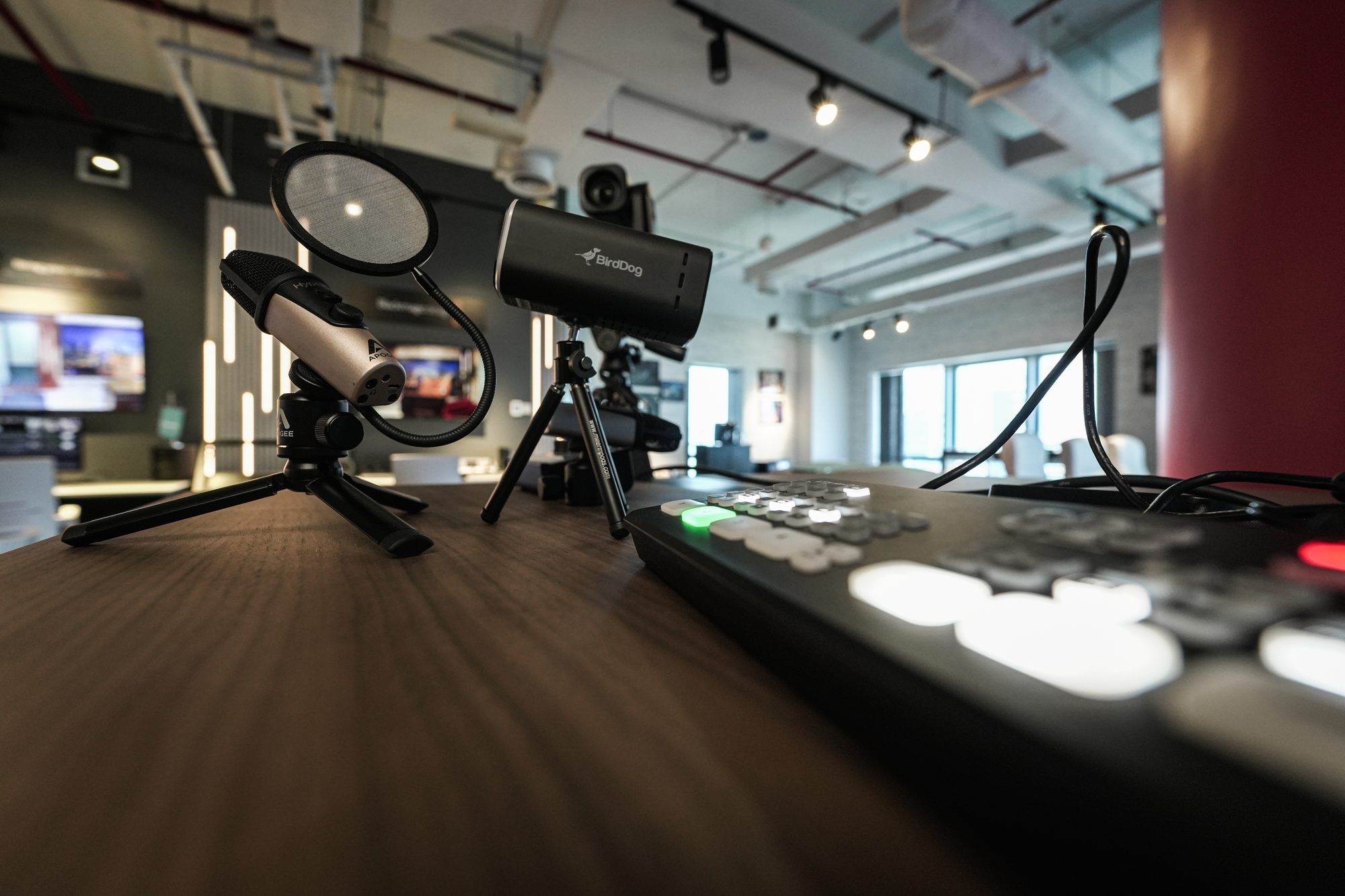 A microphone on a stand beside a lit control panel