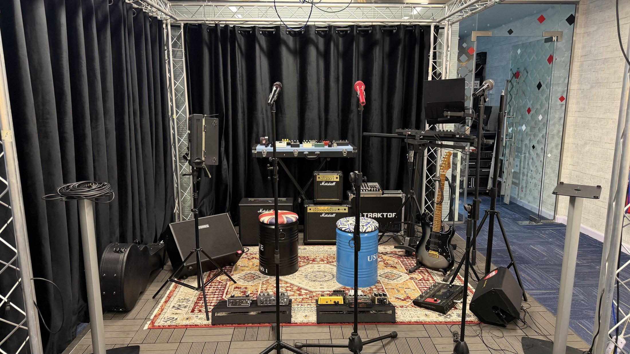 The MCX stage under the truss, amps and pedalboards on the rug