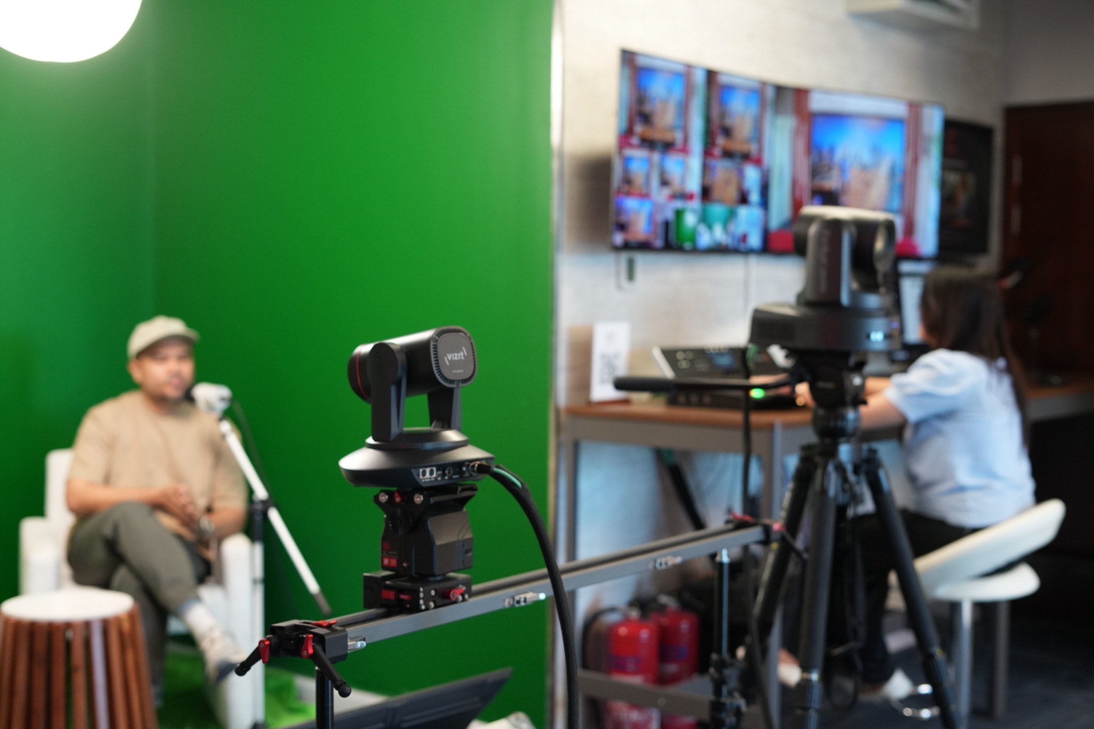 A presenter on the MCX green set while the operator tracks the shot