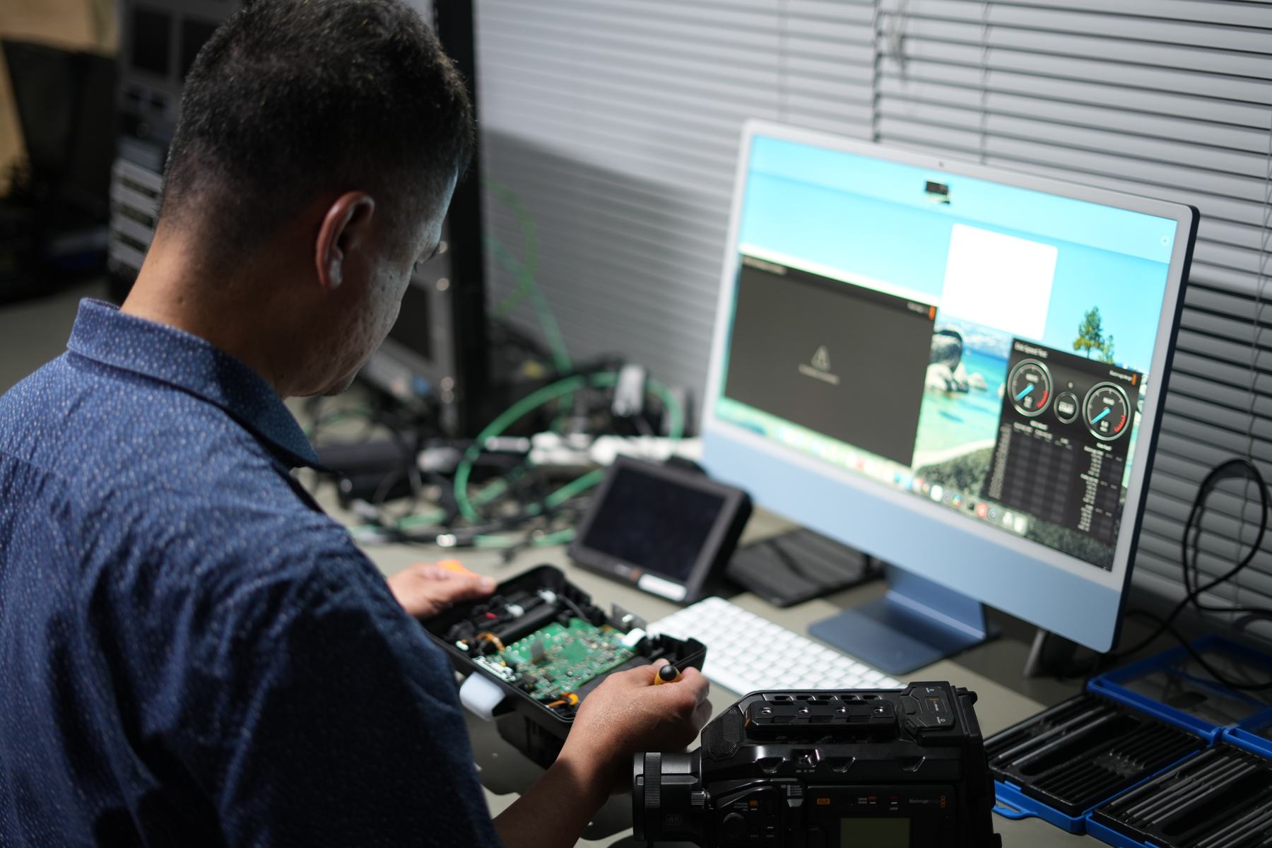 A specialist working at an MCX bench, camera and monitor in front of him